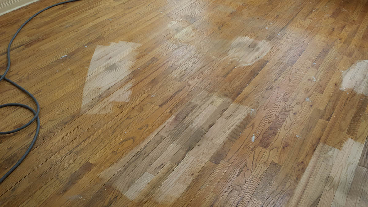 Oak hardwood floor with repaired areas before refinishing in Highland Park, IL by Midwest Hardwood Floors