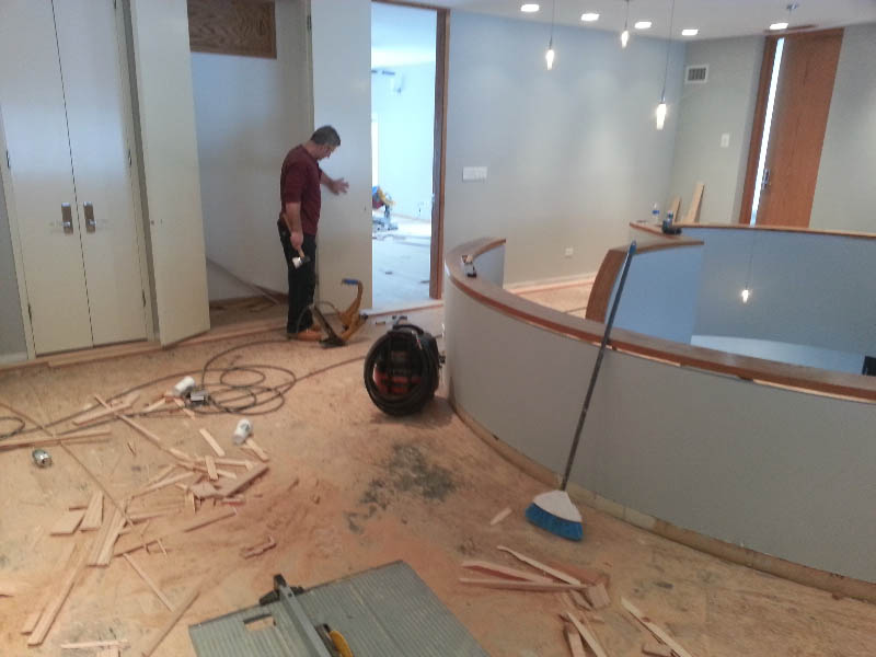 Red oak hardwood flooring and semi-circular staircase installation in progress in Chicago, IL by Midwest Hardwood Floors