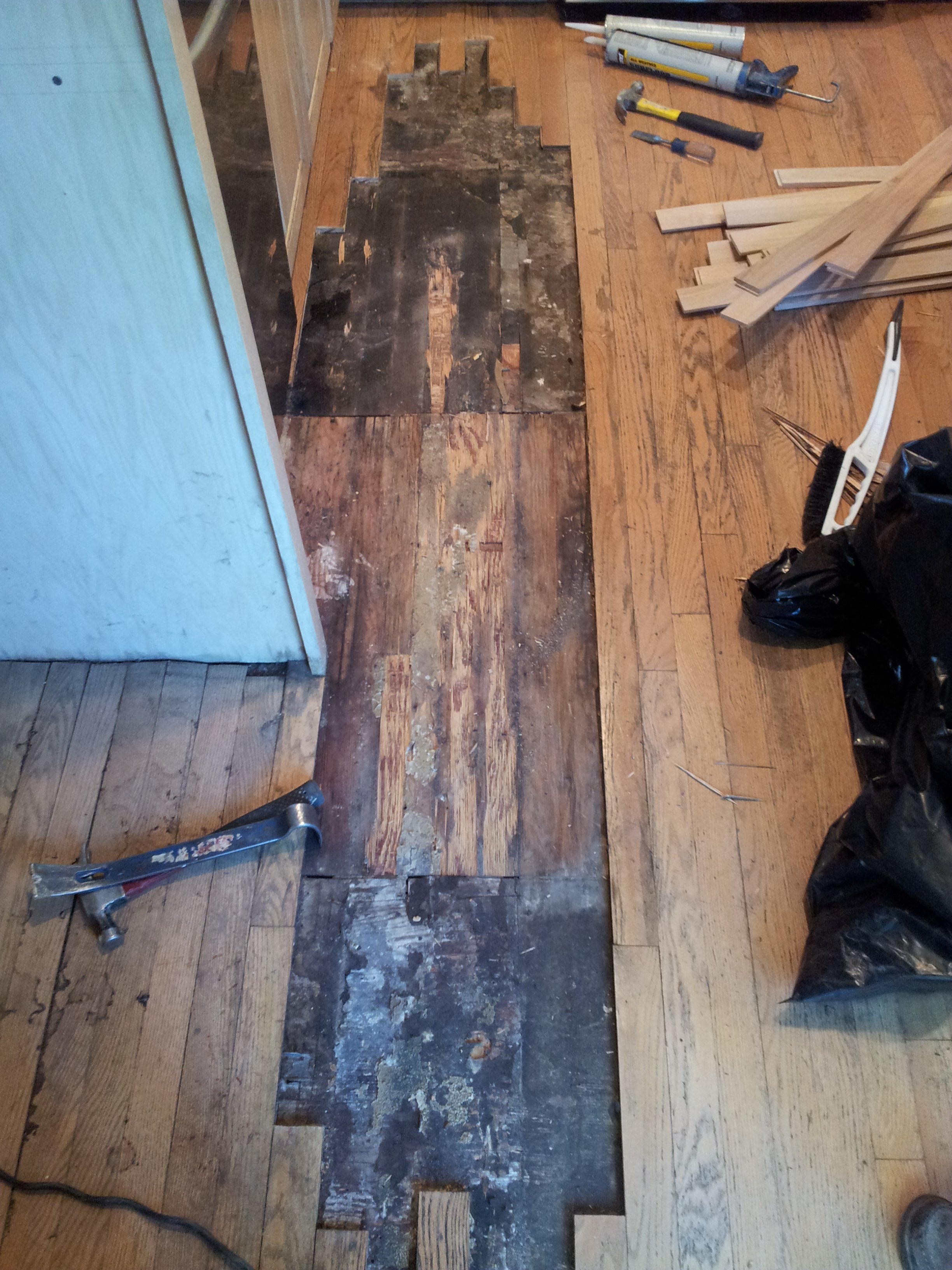 Damaged hardwood floorboards removed for replacement during floor repair in Chicago, IL by Midwest Hardwood Floors