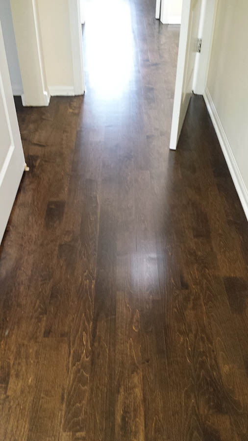Maple hardwood flooring refinished with Dark Walnut stain in a Chicago, IL hallway by Midwest Hardwood Floors