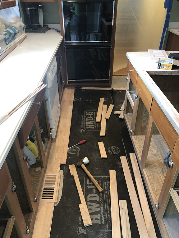 New hardwood flooring being installed in a kitchen in Morton Grove, IL by Midwest Hardwood Floors