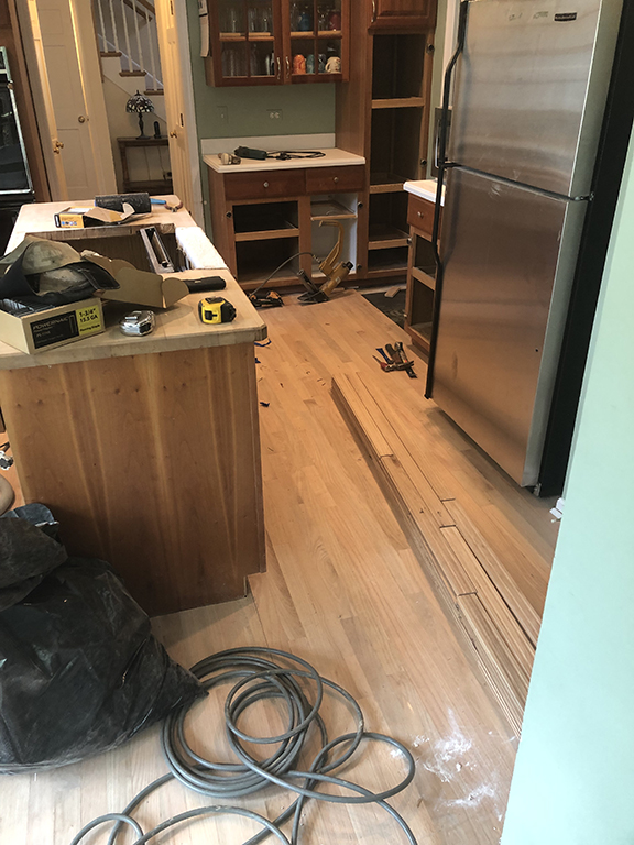 New hardwood flooring being installed after tile removal in Morton Grove, IL by Midwest Hardwood Floors