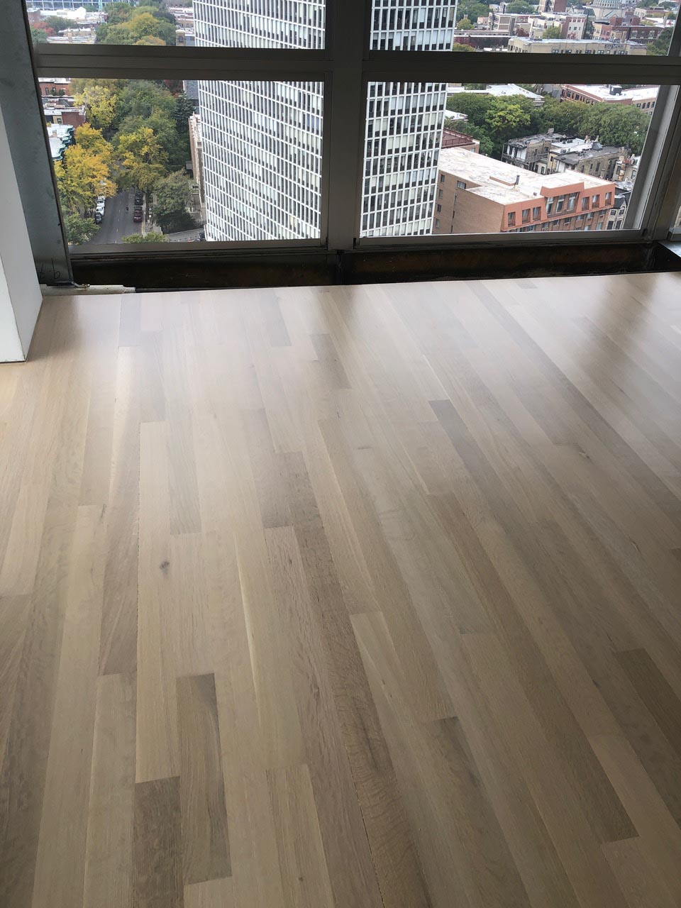 White oak hardwood flooring with Country White stain in Chicago high-rise by Midwest Hardwood Floors
