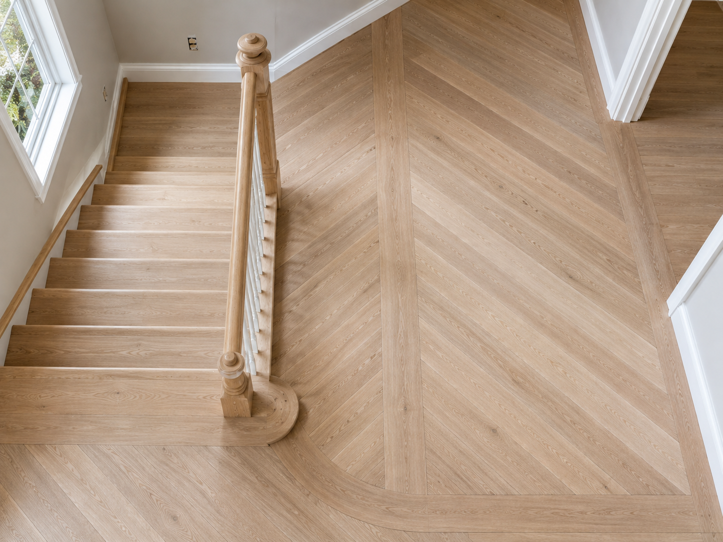 Hardwood Floor Installation in Deerfield, IL | Custom White Oak Flooring Custom unfinished white oak hardwood floor installation with chevron pattern and curved staircase in Deerfield, Illinois.